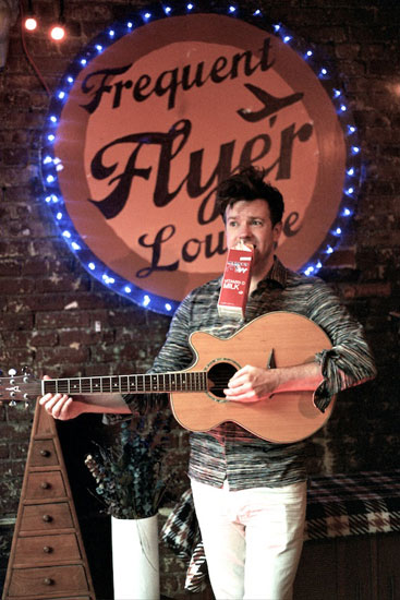 jason Sudeikis performing with his guitar.